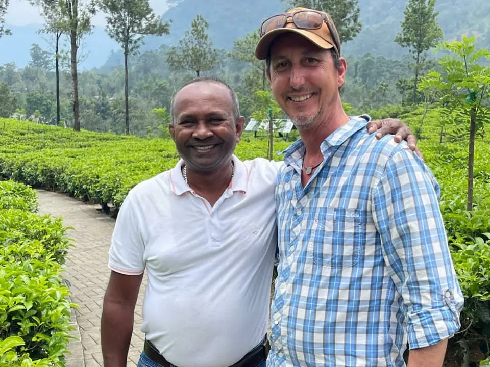 Reiseleiter Romesh mit einem Reisegast auf einer Teeplantage im Hochland Sri Lankas.